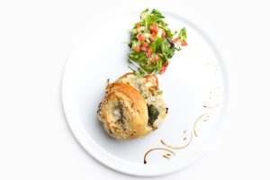 Hampton Bagel with Chicken Gorgonzola walnuts and green pesto green salad on the side isolated on white