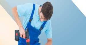 Midsection of handy man holding drill on blue, beige and white s