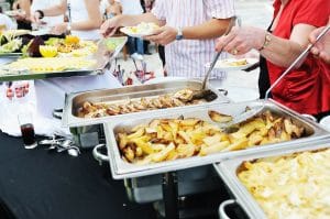 people choosing food from table on catering and buffet party on
