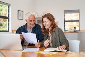 Mature smiling couple sitting and managing expenses