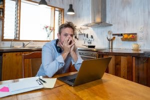 Stressed business man on laptop working
