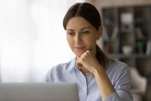 Head Shot Of Confident Focused Woman Looking At Laptop Screen