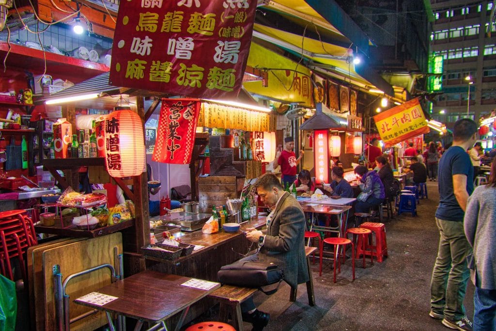 TAIPEI, TAIWAN - DECEMBER 4, 2018: People visit Raohe Night Market in Taipei. Night food markets are a big part of Taiwanese culture.