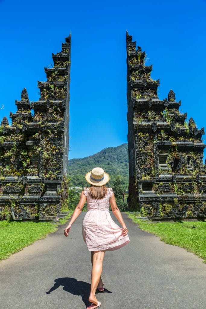 Woman traveler at Bali Handara Gate in Bali, Indonesia in a sunny day