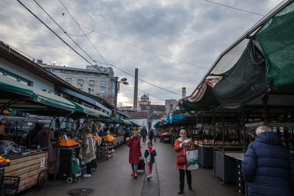 BELGRADE, SERBIA - NOVEMBER 27, 2021: Panorama of the Bajlonijeva pijaca market with sellers passing by stands selling fruits & vegetables. Bajloni is one of the main markets of Belgrade.