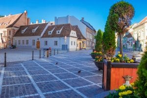 Brasov, Romania - August, 2019: Street life in center of Brasov. walk on the street between medieval cozy houses with beautiful facades. Walking tour of the city Brasov, Transylvania, Romania.
