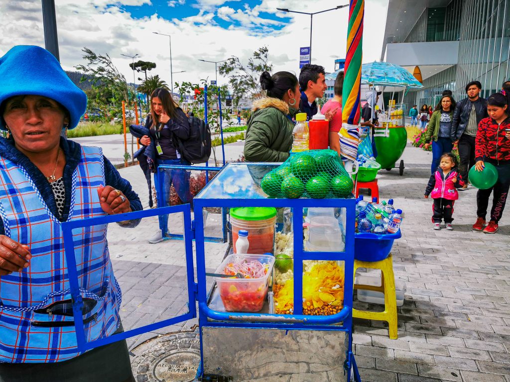 Quito, ECUADOR, 25 October 2019: Woman Street Vendor at Center of Quito ice cream and snacks.