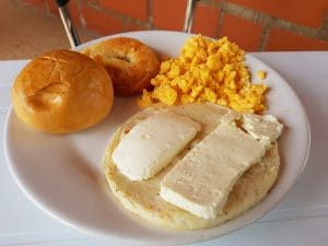 View of a paisa breakfast, scrambled egg, arepa with cheese and bread, Colombia