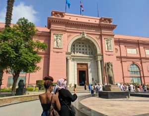 Cairo, Egypt - September 30, 2021: View of the Cairo National Egyptian Museum against the blue sky. Groups of people stand near the entrance waiting for the tour.