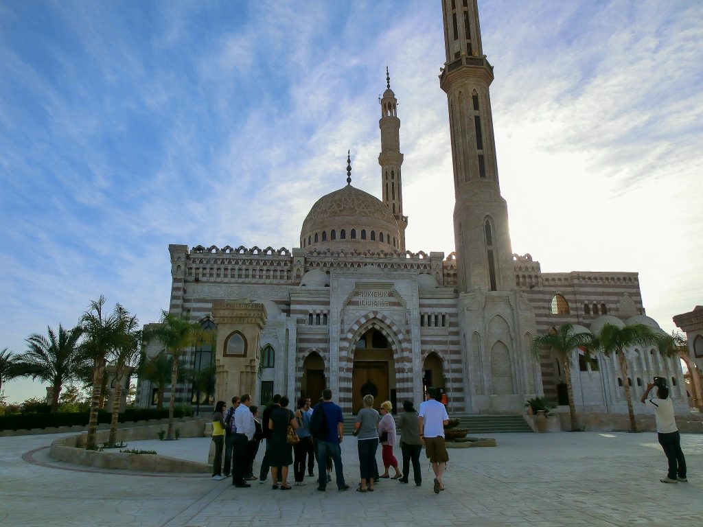 Dahab, Egypt - March 15 , 2012: tourist visiting the mosque with minaret lit by sunset