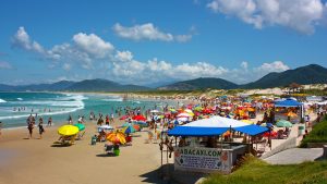 JOAQUINA BEACH, FLORIANOPOLIS, SANTA CATARINA, BRAZIL - MARCH 22, 2009: Many colorfull sunshades at the beach. People relaxing and enjoying the sun and the sea.