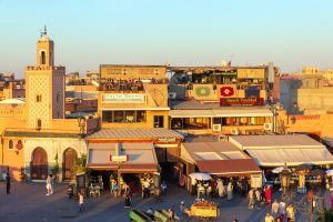 MARRAKECH, MOROCCO - APR 27, 2016: Mosque and restaurants with tourists on the Djemaa-el-Fna square in Marrakech