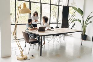 Group of happy smiling young people sharing ideas in spacious coworking loft space