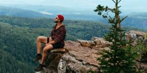 A man traveler sitting on the edge of a cliff