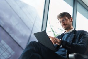 Business Man Using His Tablet Computer During A Trip.