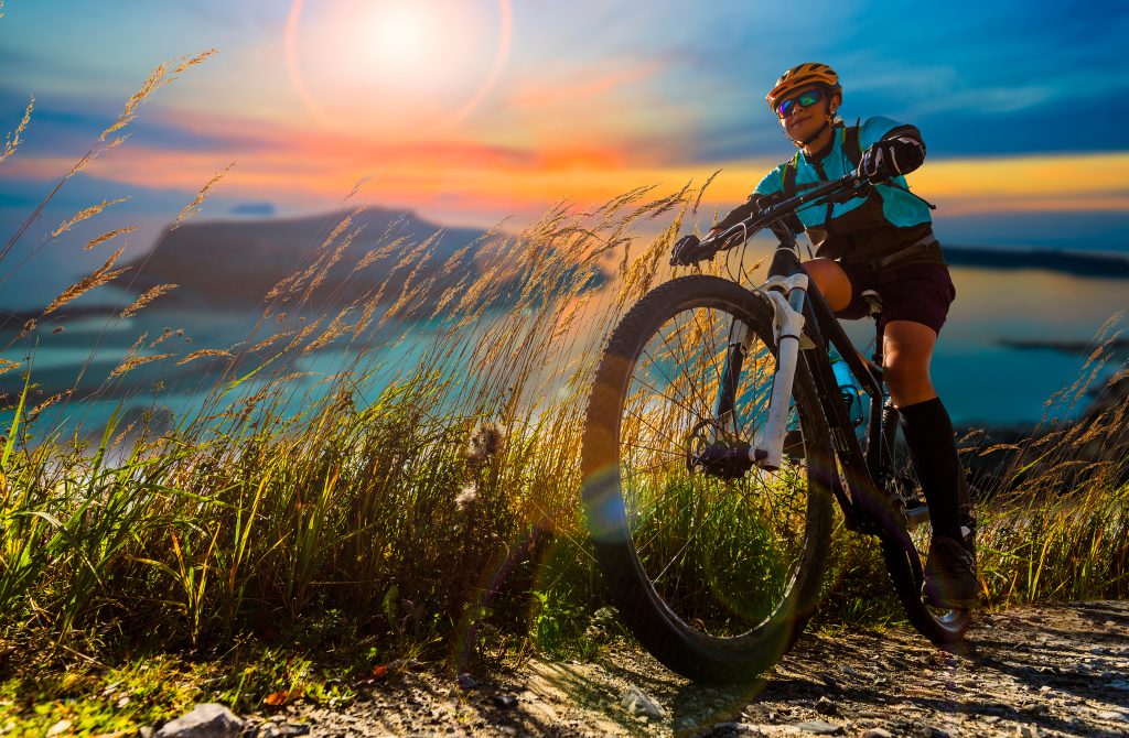 Cycling woman on electric bikes. MTB enduro trail track. Outdoor