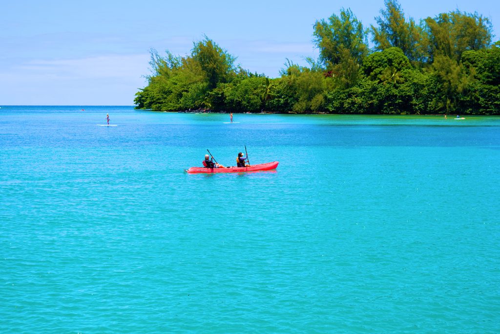 People kayaking on the warm turquoise waters of Hanalei Bay