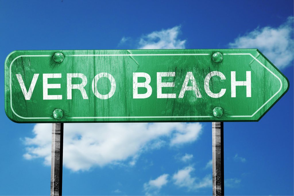 vero beach road sign on a blue sky background
