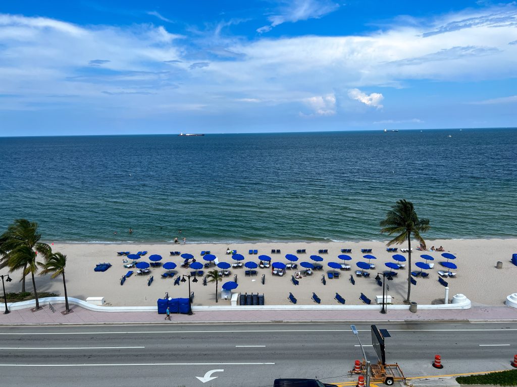 Ft. Lauderdale, FL USA - June 6, 2022: An aerial view of the beach at Ft. Lauderdale, Florida on a sunny summer day with umbrellas and chairs.